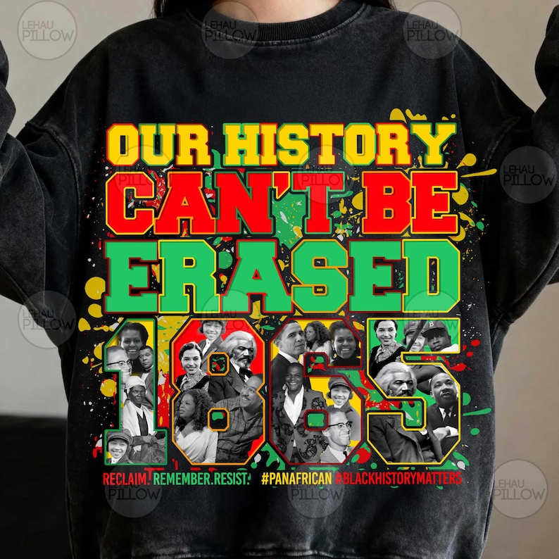 Op de afbeelding: Een zwart sweatshirt met ronde hals en een grafische print met de tekst "OUR HISTORY CAN'T BE ERASED" in geel, rood en groen. Het ontwerp bevat een collage van historische figuren, verfspatten en de tekst "REMEMBER. RESIST. #PANA