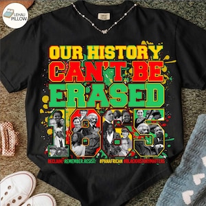 Könnte beinhalten: Ein schwarzes T-Shirt mit dem gelben, roten und grünen Schriftzug "OUR HISTORY CAN'T BE ERASED" über einer Collage aus schwarz-weißen Porträts historischer Persönlichkeiten und dem Text "RECLAIM. REMEMBER. RESIST. #PANAFRICAN #BLACKHISTORYMATTERS" darunter.