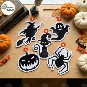 Könnte beinhalten: Fünf schwarze Filzaufnäher zum Thema Halloween mit weißem Rand, nummeriert von eins bis fünf. Die Motive zeigen eine Hexe auf einem Besen, ein Gespenst, eine Katze mit Hexenhut, einen Kürbis und eine Spinne auf einer Holzoberfläche.