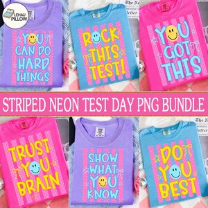 Peut inclure: Plusieurs t-shirts colorés avec des messages positifs pour le jour des examens. Chaque chemise présente un smiley et des phrases comme "You Can Do Hard Things" et "Rock This Test!" en couleurs néon sur un fond rayé.