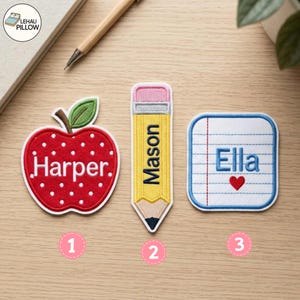 Pode incluir: Três emblemas bordados: uma maçã vermelha com bolinhas brancas e o nome Harper, um lápis amarelo com o nome Mason e uma folha de papel de caderno quadrada branca com linhas azuis, o nome Ella e um pequeno coração vermelho. Borda branca.