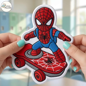 May include: An embroidered patch featuring a red and blue superhero character with a black web pattern on the red sections, riding a red skateboard with a white web design and a small black spider graphic, finished with a white border.