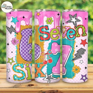 Pode incluir: Três canecas isoladas coloridas de 590 ml com fundo rosa, amarelo e azul turquesa. Cada caneca apresenta os números "6" e "7" com estrelas, flores e raios decorativos. A palavra "Six" também é visível.