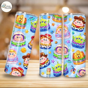 May include: Three cylindrical tumblers featuring a repeating pattern of cartoon characters in space-themed outfits against a light blue background with stars, planets, and rockets. The design includes colourful illustrations of various figures.