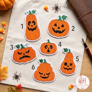 May include: Six orange embroidered pumpkin patches with various black facial expressions, numbered one through six. Each patch features a green stem and white border, arranged on a light-colored fabric surface with scattered candy corn.