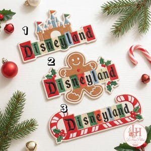 May include: Three embroidered patches featuring the word Disneyland in black lettering on colorful rectangular blocks. Patch 1 shows a tan castle, patch 2 features a brown gingerbread person with holly, and patch 3 includes a red and white candy cane.