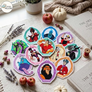 May include: A collection of circular embroidered patches featuring various animated characters, each framed in a decorative border. The patches display figures including a lion, a sea witch, a sorcerer, and other villains, rendered in vibrant colors.