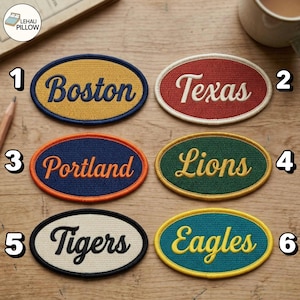 May include: Six oval embroidered patches with stitched borders. Patch 1 is yellow with blue text 'Boston'. Patch 2 is red with white text 'Texas'. Patch 3 is blue with orange text 'Portland'. Patch 4 is green with yellow text 'Lions'. Patch 5 is cream with black text 'Tigers'. Patch 6 is teal with yellow text 'Eagles'.