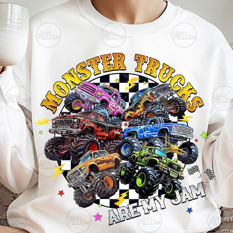 Peut inclure: Sweat-shirt blanc avec un motif color&eacute; de monster trucks de diff&eacute;rentes couleurs, dont rose, orange, bleu et vert. Le texte "MONSTER TRUCKS ARE MY JAM" est affich&eacute; dans un cercle avec des &eacute;clairs et des &eacute;toiles.