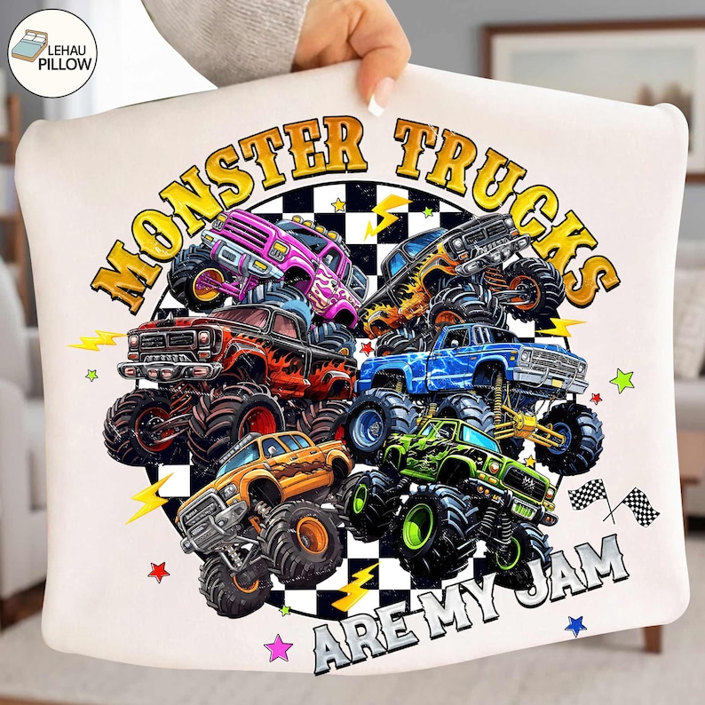 Peut inclure: Coussin blanc avec un motif color&eacute; de monster trucks. Le design pr&eacute;sente plusieurs monster trucks de diff&eacute;rentes couleurs, avec le texte "MONSTER TRUCKS ARE MY JAM" en gras. Des &eacute;toiles, des &eacute;clairs et des drapeaux &agrave; damier compl&egrave;tent le design.