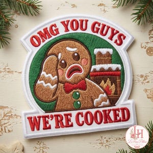 May include: An embroidered patch featuring a brown gingerbread person with a red bow tie and green buttons, looking distressed with a hand to its head. Beside it is a fireplace with flames. The text reads OMG YOU GUYS WE'RE COOKED in red.