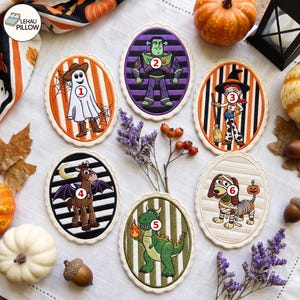 May include: Six oval embroidered patches featuring Toy Story characters in Halloween costumes: a ghost, a space ranger, a witch, a bat, a dragon, and a mummy dog. Each patch has a scalloped edge and a numbered white circle on the character.