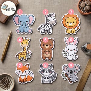 May include: A collection of nine numbered animal stickers featuring a blue elephant, a zebra, a lion, a giraffe, a brown bear, a white rabbit, a fox, a raccoon, and a koala. The stickers are arranged in a grid on a textured surface with a pen and ruler.