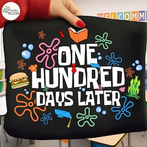 May include: Black pillow with the text "ONE HUNDRED DAYS LATER" in white, surrounded by colorful cartoon graphics. Includes a hamburger, open book, graduation cap, and sea-themed designs.