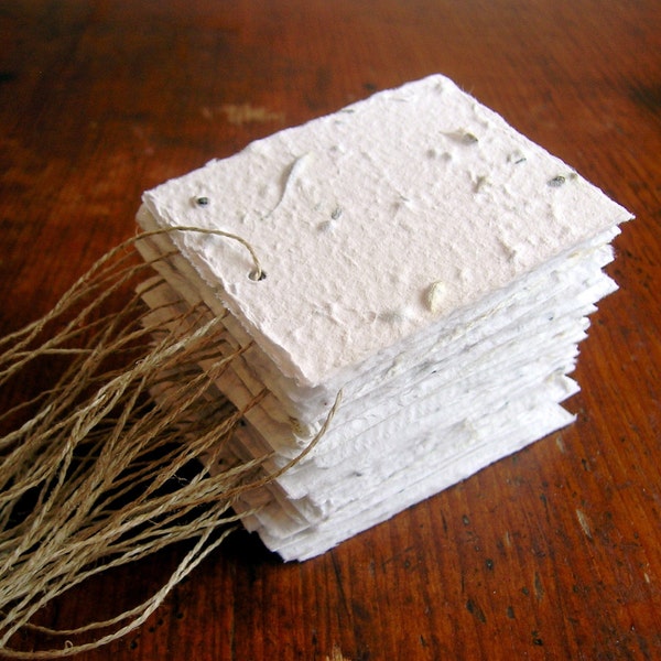 White tags made of plantable handmade paper embedded with perennial flower seeds