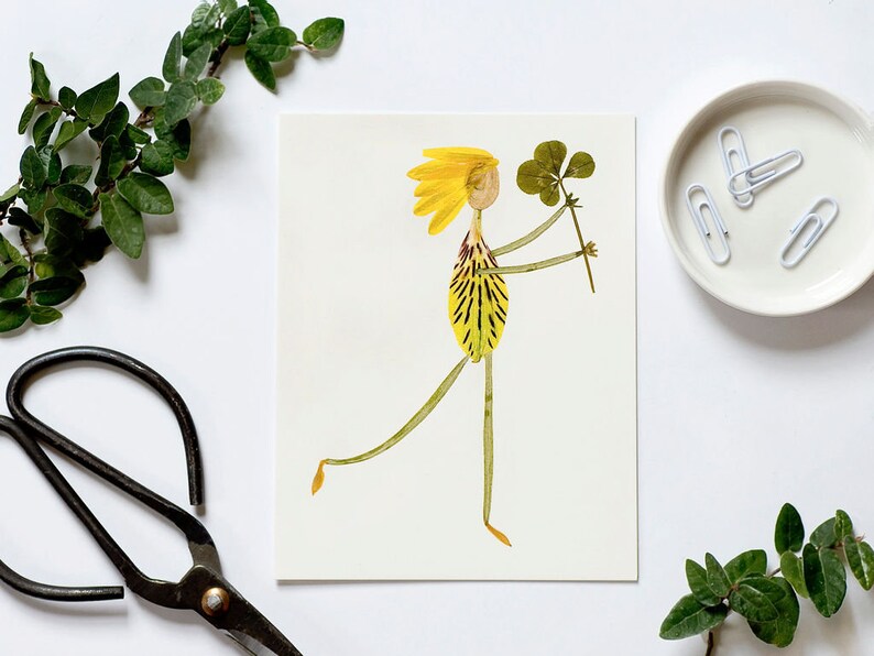 May include: A whimsical illustration of a person made from pressed flowers. The person is wearing a yellow dress and has yellow hair. They are holding a four-leaf clover in their hand.
