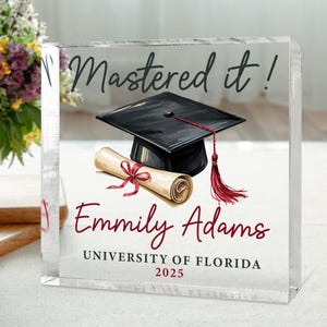 May include: A clear glass block with a graduation cap, diploma, and the text "Mastered it!"  "Emliy Adams" "UNIVERSITY OF FLORIDA" "2025"