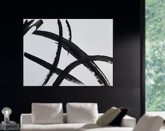 May include: A black and white abstract painting with bold, thick brushstrokes. The painting is framed and hanging on a black wall in a modern living room.