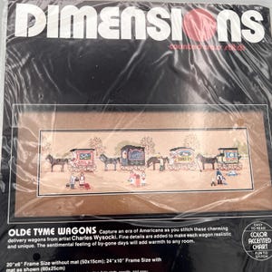 May include: A Dimensions counted cross stitch kit titled Olde Tyme Wagons featuring a horizontal scene of horse-drawn delivery wagons for milk, florist, bakery, and ice. The package includes a color accented chart and lists a 20x6 inch frame size.