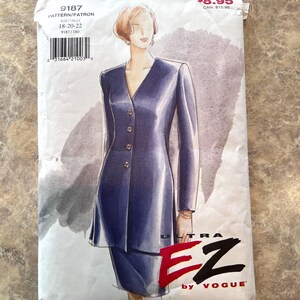 May include: A sewing pattern packet featuring a blue dress design with a V-neck and button details. The packet includes the text "9187" and "ULTRA EZ by VOGUE". The illustration shows a woman wearing the dress. Size 18-20-22.