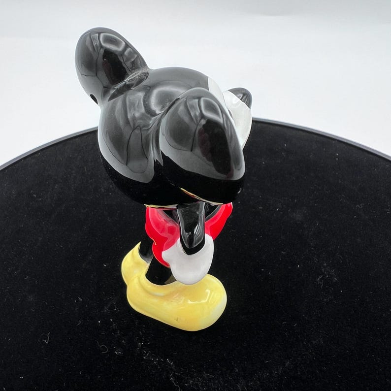 Peut inclure: Figurine de Mickey Mouse noir brillant, avec un short rouge, des gants blancs et des chaussures jaunes. La figurine de collection a un design classique et est pos&eacute;e dans une posture ludique. La figurine est un personnage populaire de Disney.