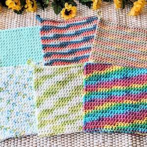 May include: Six crocheted dishcloths in various colors and patterns, including green, blue, white, and pink. The dishcloths are made with a variety of stitches and textures.