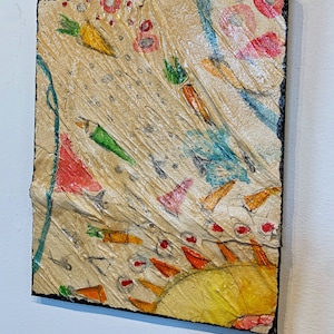 Puede incluir: Obra de arte abstracta sobre un lienzo cuadrado. La obra presenta un fondo beige con ilustraciones coloridas de zanahorias, triángulos y círculos. Los bordes del lienzo son negros.