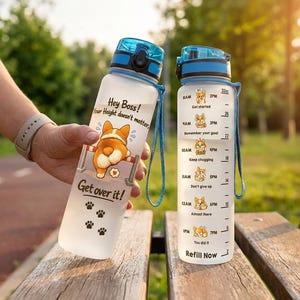 May include: Two frosted plastic water bottles with blue lids and carrying straps. One bottle features a corgi illustration with the text "Hey Boss! Your Height doesn't matter, Get over it!" and paw prints. The other shows a 32oz hourly intake tracker.