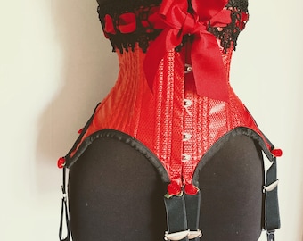 May include: A red corset with a textured pattern, black lace trim, and a large red bow. The corset features a row of small buttons down the front and black garter straps with metal clasps. Small red roses are attached to the garter straps.