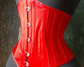 May include: A red satin corset with silver metal clasps. The corset has a smooth, shiny finish and a classic design.