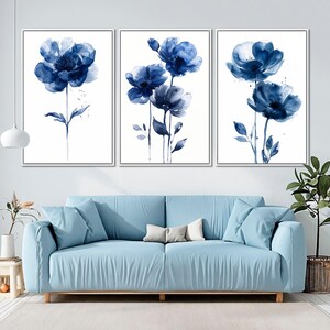 a living room with a blue couch and two paintings on the wall