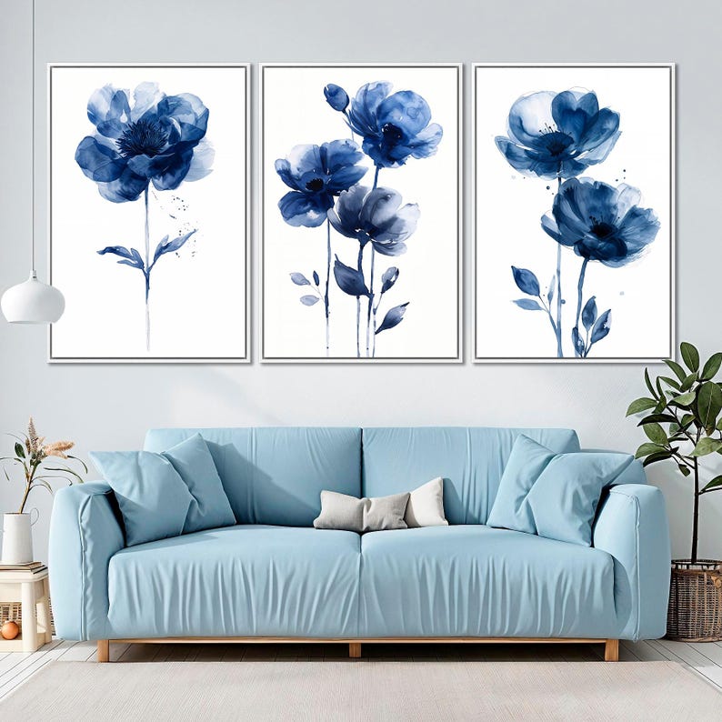 a living room with a blue couch and two paintings on the wall