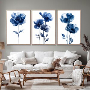 a living room filled with furniture and paintings on the wall