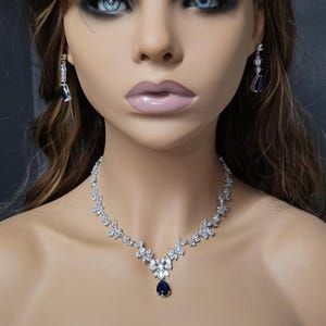 Silver Blue Crystal Bridal Jewelry Set Teardrop Earrings and necklace on model with long brown hair.