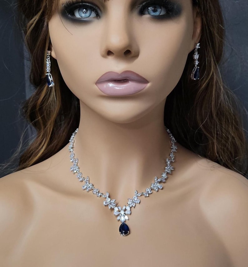 Silver Blue Crystal Bridal Jewelry Set Teardrop Earrings and necklace on model with long brown hair.