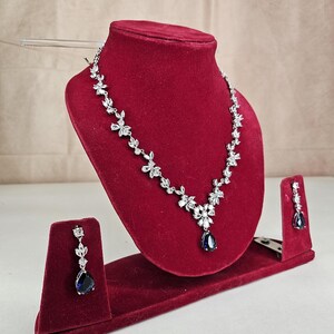 Blue Crystal Bridal Jewelry Set Teardrop Necklace and Earrings on model with long brown hair.