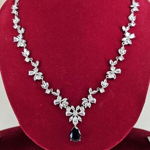 Silver Blue Crystal Bridal Jewelry Set Teardrop Necklace and Earrings on red display model with long brown hair.