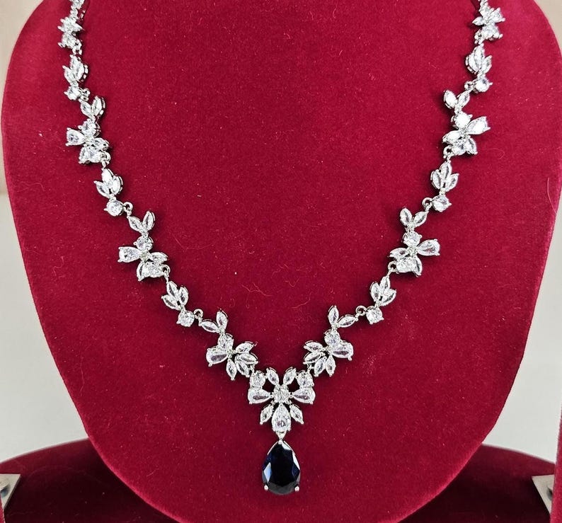 Silver Blue Crystal Bridal Jewelry Set Teardrop Necklace and Earrings on red display model with long brown hair.