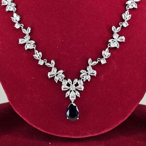 Silver Blue Crystal Bridal Jewelry Set Teardrop Necklace and Earrings on red display model with long brown hair.
