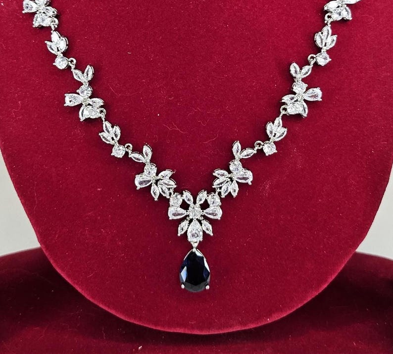 Silver Blue Crystal Bridal Jewelry Set Teardrop Necklace and Earrings on red display model with long brown hair.