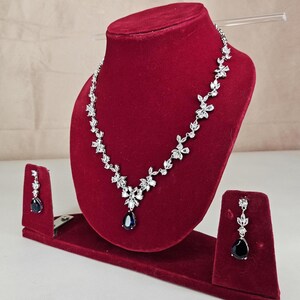 Silver Blue Crystal Bridal Jewelry Set Teardrop Necklace and Earrings on red display model with long brown hair.