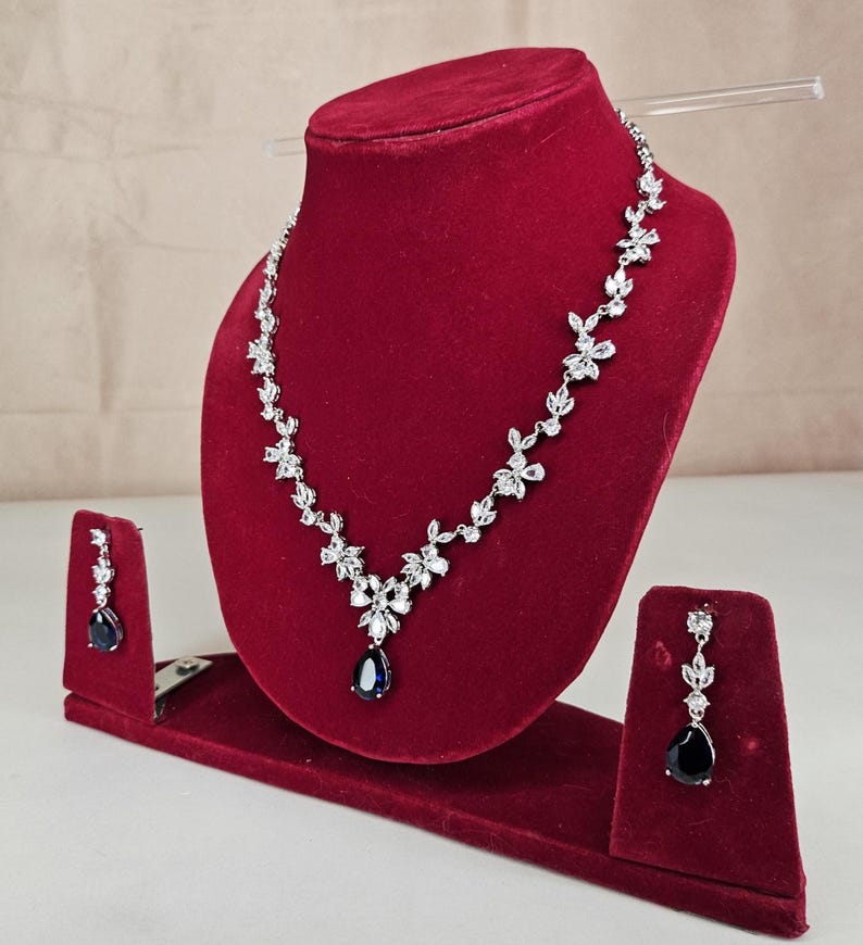 Silver Blue Crystal Bridal Jewelry Set Teardrop Necklace and Earrings on red display model with long brown hair.