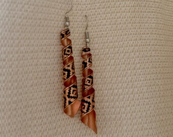 May include: A pair of dangle earrings with a brown and black patterned design. The earrings are made of metal and have a spiral shape.