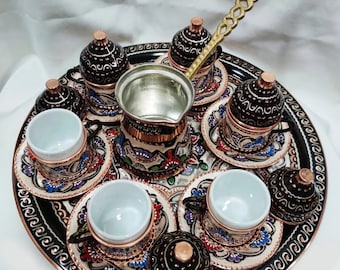 May include: A traditional Turkish coffee set featuring a copper tray, six cups, and a coffee pot. The set is decorated with intricate floral patterns in shades of blue, red, and green.