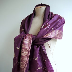 May include: A purple silk shawl with gold embroidery featuring floral and paisley designs. The shawl is draped over a mannequin.