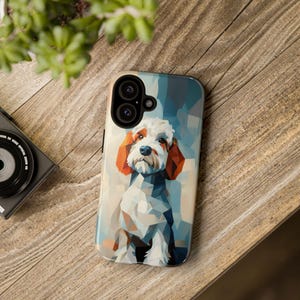 Puede incluir: Una funda de teléfono con un diseño geométrico de un perro blanco con orejas naranjas. El fondo es un patrón abstracto azul y blanco.