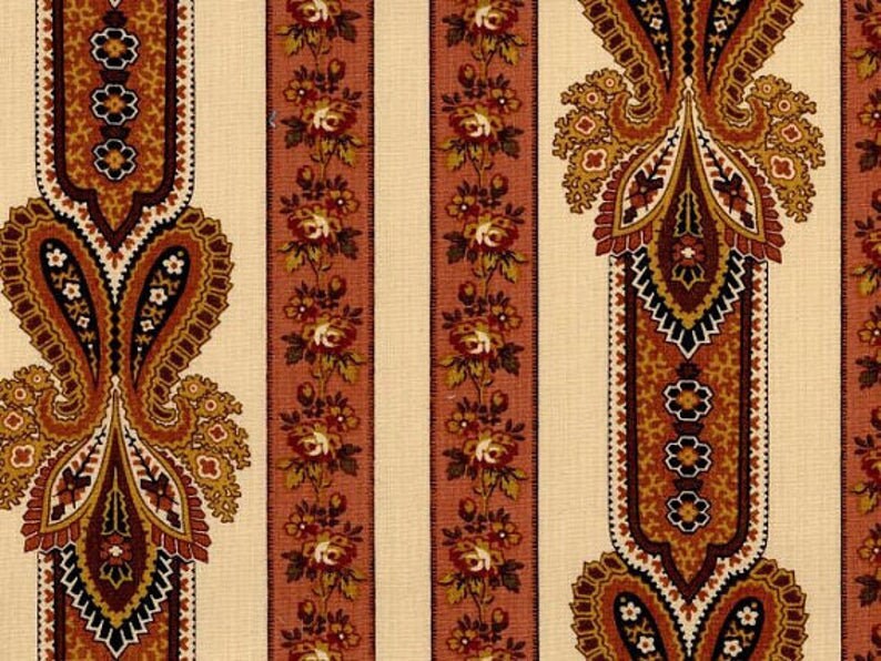 May include: A vintage fabric with a repeating pattern of paisley motifs and floral designs in shades of brown, orange, and white on a cream background.