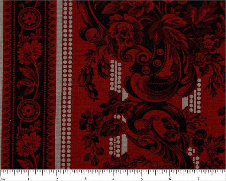 May include: Red fabric with a black and white patterned design. The pattern features a repeating floral motif with intricate details. The fabric has a textured surface.