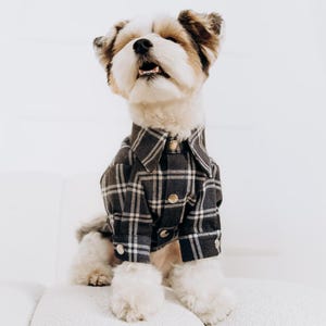 May include: A white ceramic mug with a black handle and the text "But First, Coffee" in a black, bold font. The mug is on a white surface.