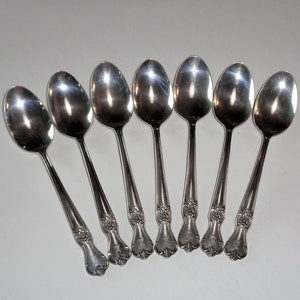 May include: Set of seven silver teaspoons with ornate floral designs on the handles.
